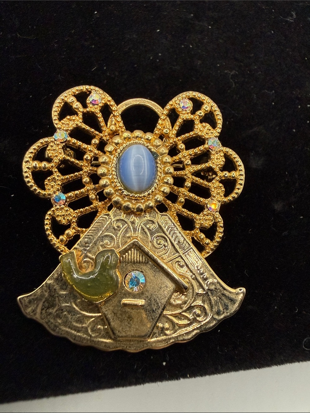 vintage gold-tone angel brooch features a filigree halo, a blue cabochon stone…